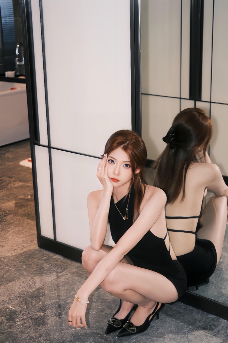 穿黑色晚宴洋裝的成年女性室內形象照